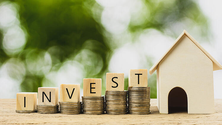 invest letters with wooden house